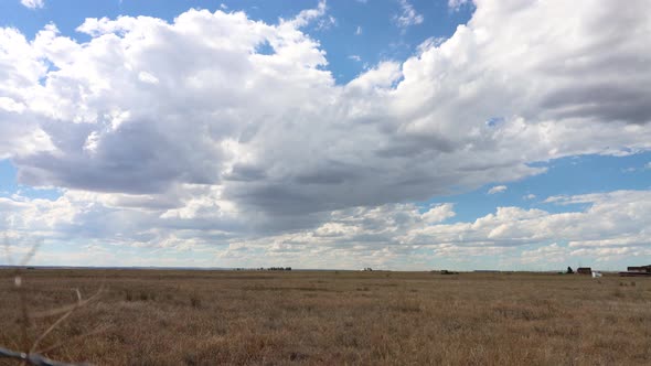 A western prairie time lapse with thousands of puffy white clouds and shadows crawling across the sk