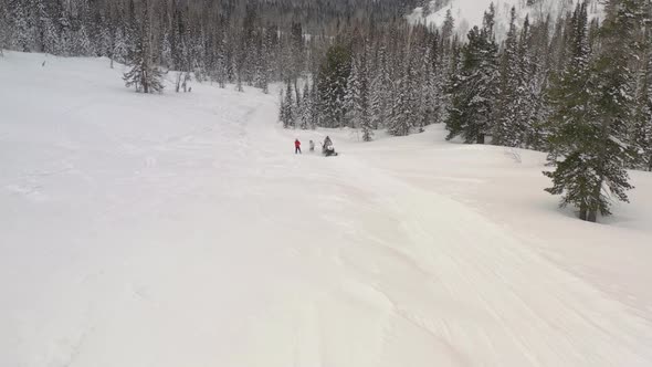 Aerial View of Men Ride Up a Mountain on Skis and Snowboards Holding on To a Rope Tied To a