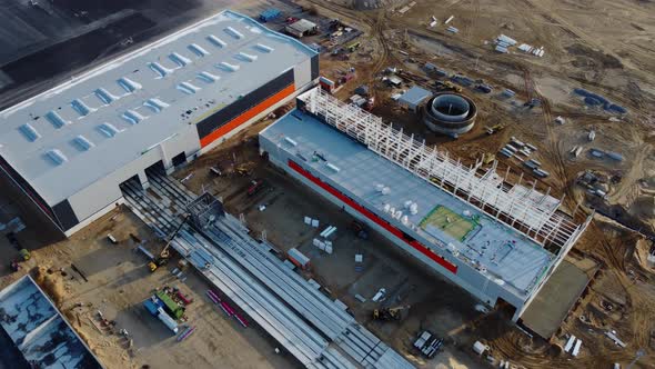 Aerial Drone Shot Over a New Constructions Development Site Warehouses Projects and Heavy Machinery