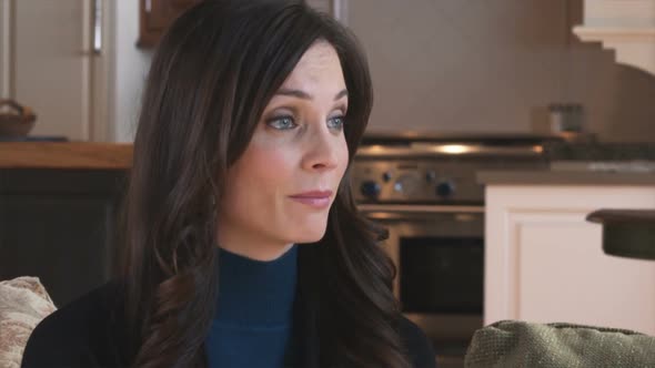 Close-up of a woman listening to another.