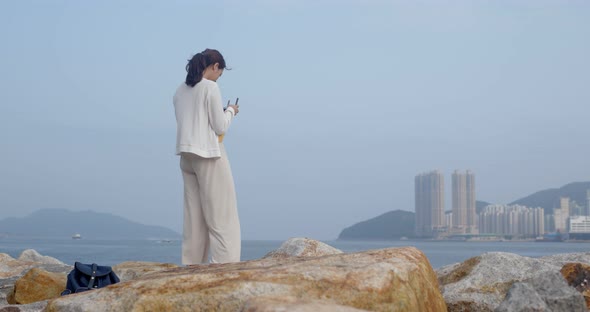Woman fly a drone and stand at the sea side