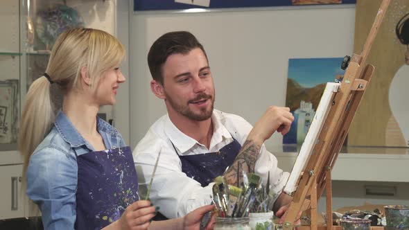 Happy Couple Painting a Picture Together on a Date at Art Studio