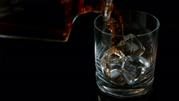 Super Slow Motion Shot of Pouring Whiskey From Bottle Into Glass with Ice Cubes at 1000Fps