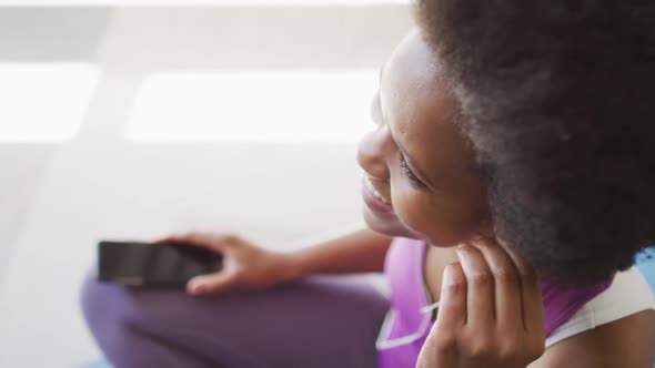 Happy african american wearing sportswear and earphones, exercising