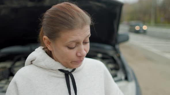 Woman Wtanding At Broken Car Searching For Repair Service