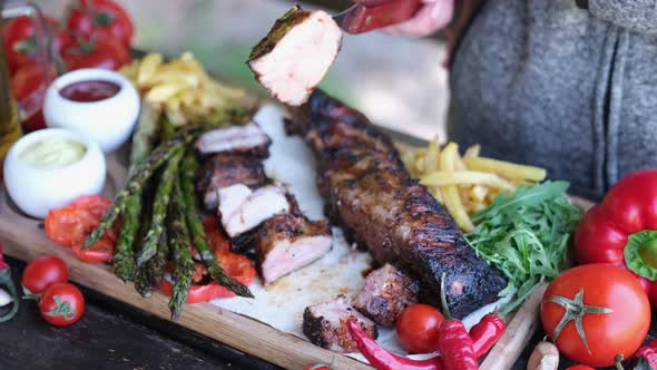 Delicious Beef or Pork Grilled Ribs Served with Aspargus and French Fries on a Wooden Board