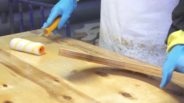 Industrial Carpenter Worker Varnishing on Wood