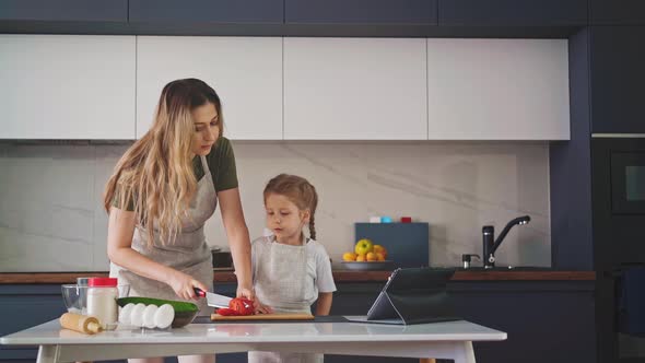 Mother in an Apron in Kitchen at Table with Ingredients