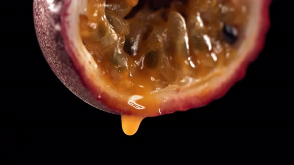Slow Motion Macro Shot of Flowing Passion Fruit Maracuya Juice From Halved Maracuya