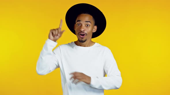 Happy African American Guy in Black Hat Showing Eureka Gesture. Portrait of Young Man Having Idea