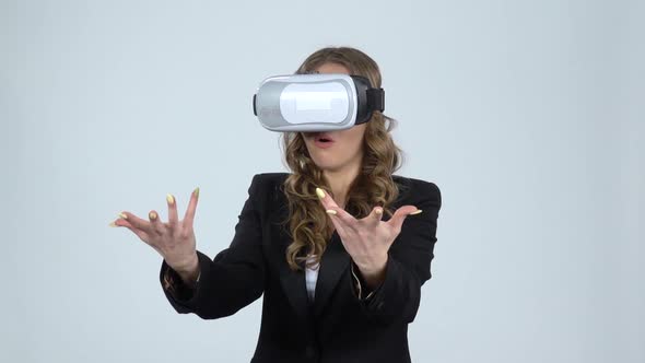 Woman with Virtual Reality Glasses on Her Head on Gray Background, Slow Motion.