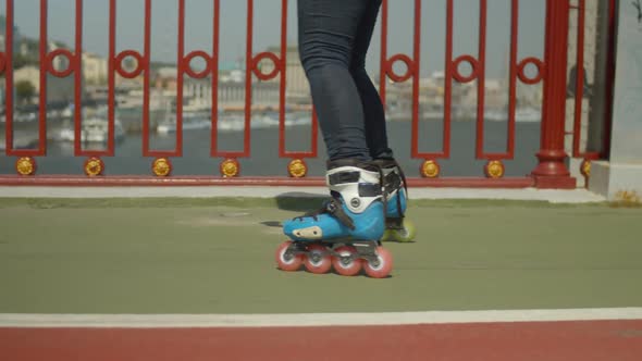 Female Roller Feet Riding Backwards on City Bridge