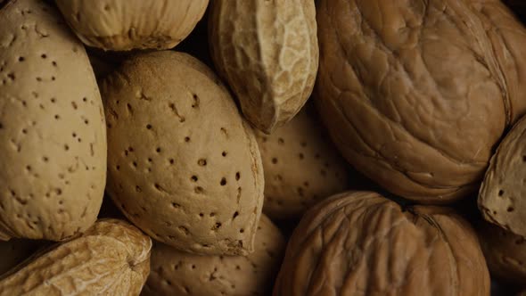 Cinematic, rotating shot of a variety of nuts on a white surface - NUTS MIXED