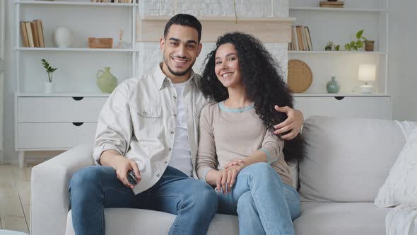 Married Couple Husband and Wife Curlyhaired Beautiful Woman and Arabic Man Spaniard Sitting on Sofa