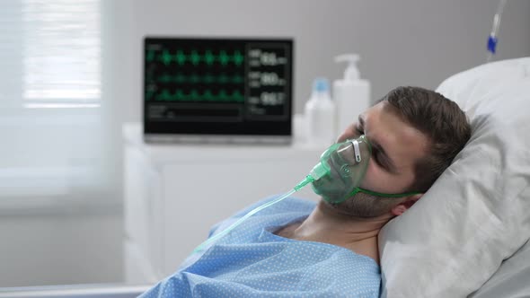 Caucasian Man with Oxygen Mask on Lying in Bed with White Linen Sleeping Disturbingly Moving Head