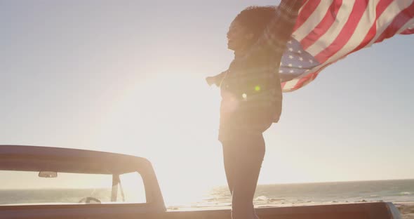 Woman standing with waving american flag on a pick up truck 4k