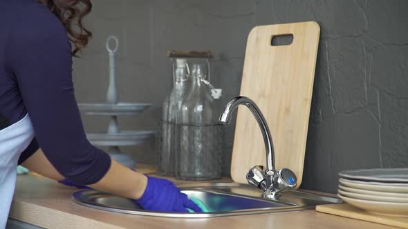 Woman Wiping Kitchen Sink with Microfiber Cloth