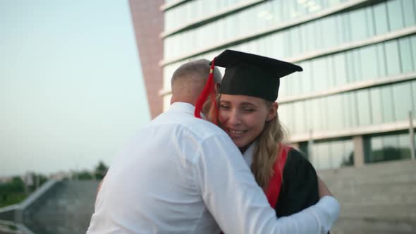 Slow Motion Graduation a Father Embraces His Daughter a University Graduate Female in a Graduate's