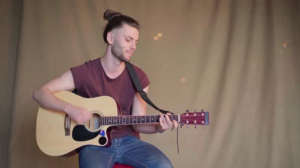 Handsome Young Man Playing Acoustic Guitar Sitting Chair Fabric Background