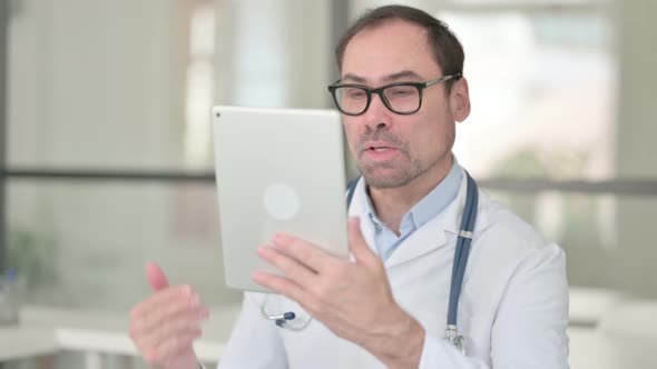 Middle Aged Doctor Doing Video Chat on Digital Tablet