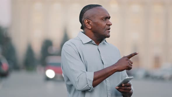 Adult Mature Black Man Holding Smartphone Looking at Phone Screen Look for Address with Electronic