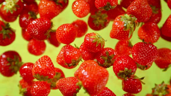 Super Slow Motion Shot of Fresh Strawberries on Green Background Flying Towards Camera at 1000Fps