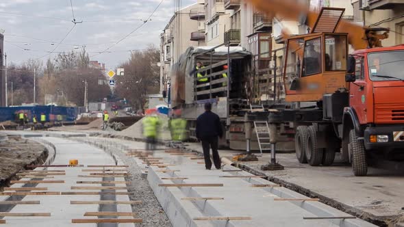 Tram Rails at the Stage of Their Unloading From Truck By Crane on Concrete Plates on the Road