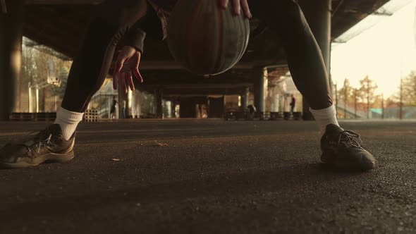 Basketball Player with a Ball on the Background of a Street Court