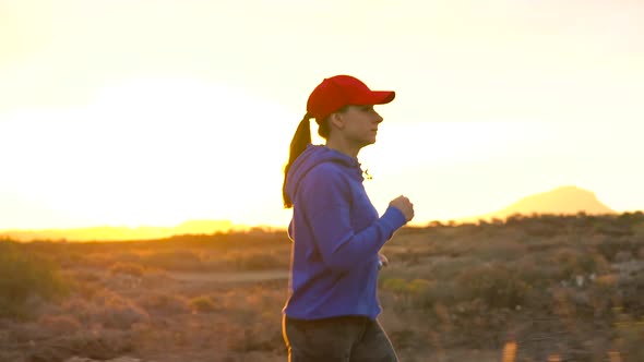 Woman Runs Along the Deserted Area at Sunset