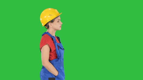 Construction worker lady walking emotionless on a Green