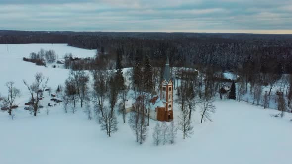 Aerial Top View of the Krimulda Evangelic Lutheran Church in Winter at Sunrise Latvia 4k Video