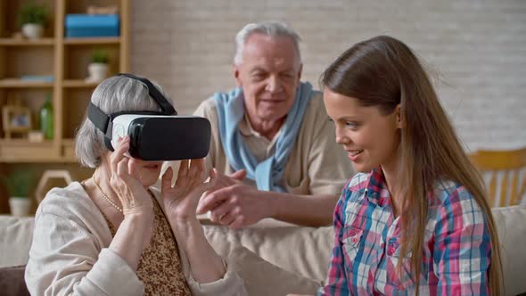 Young Woman Explaining VR Headset to Grandparents