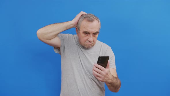 Happy Senior Elderly Man Holding Smart Phone Watching Mobile Video Calling Online Looking at Screen