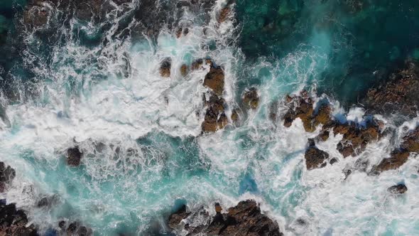 Ocean Surf. Waves Are Breaking on Stones, Wave Foaming and Splashing Ocean Surf, Aerial Top Down