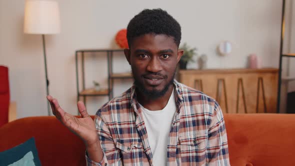 Man Sitting on Home Sofa Looking at Camera Making Video Conference Call with Friends or Parents