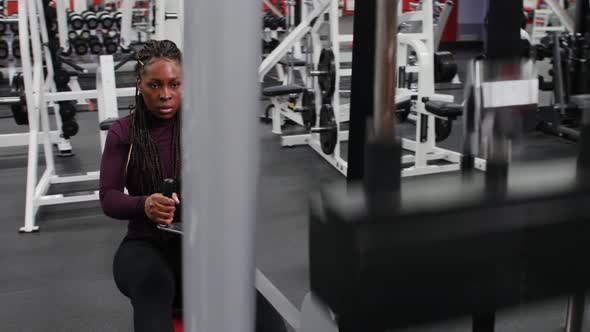 Sports Training Indoors Black Woman with Braids Training Her Hands on a Exercise Equipment Then