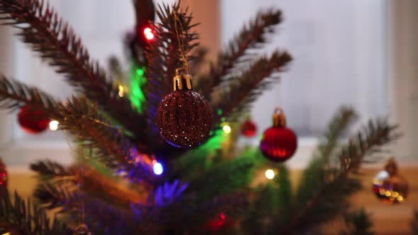 Close up shot of a beautifully decorated christmas tree inside house. Camera slowly zoom out on the