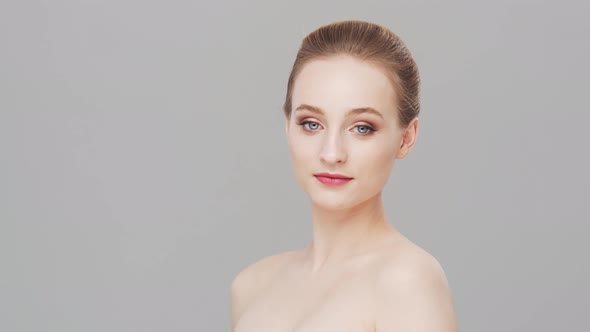 Studio portrait of young, beautiful and natural woman over grey background.