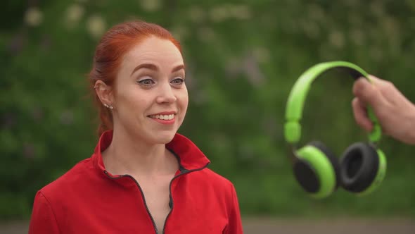 Girl Looks at Headphones