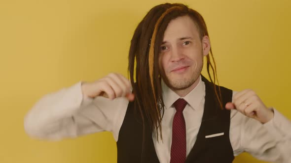 Young Man with Long Dreadlocks Dancing on Yellow Background