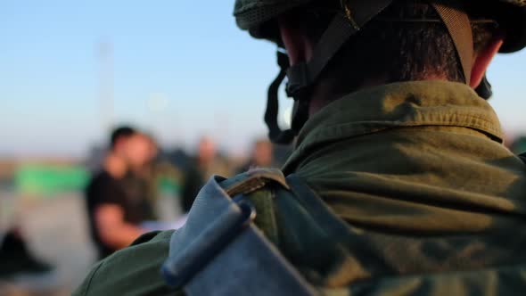 Close-up of a combat soldier's neck when in the background his commander gives his team instructions