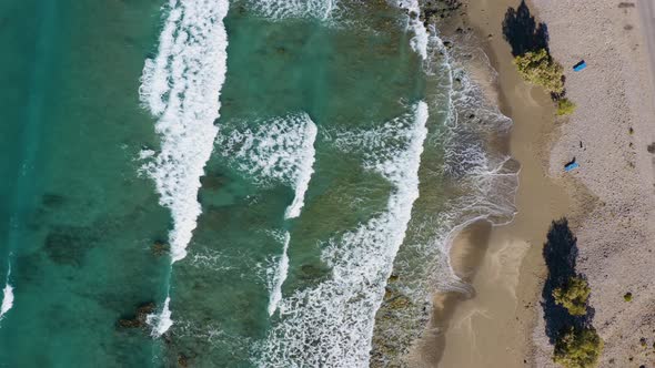 Top aerial view of Waves crashing against the beach. Flying above Sand Beach