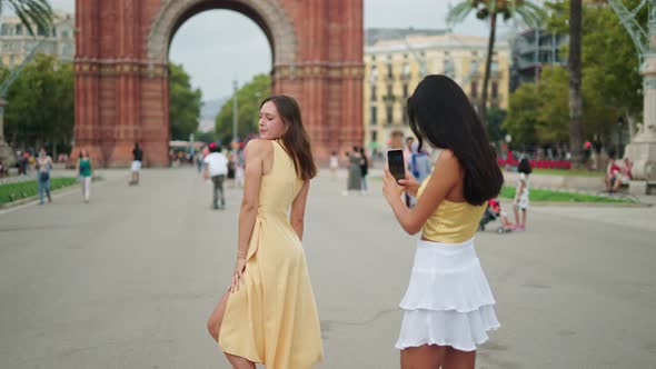 Woman Photographing Female Best Friend Outdoors Near Historic Building