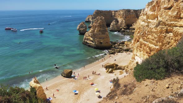 Slowmotion Wideshot of Marinha Beach Portugal During Sunny Weather with Small Amount of Tourists Sun
