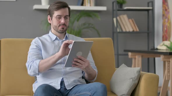 Young Man Using Tablet on Sofa