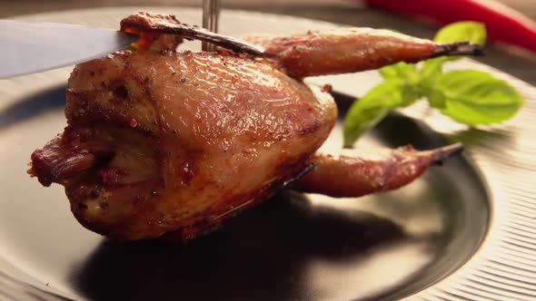 Closeup View of a Fork and Knife Cutting a Piece of Delicious Fried Quail