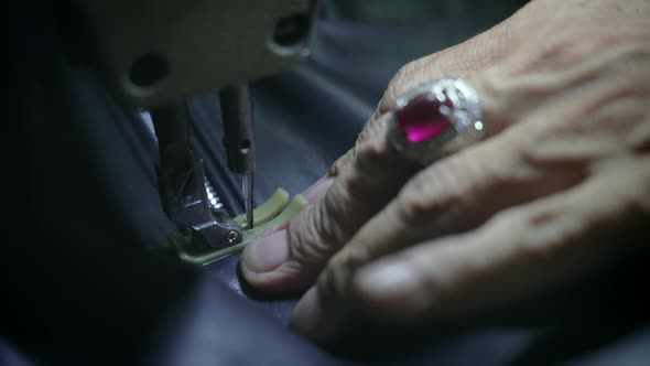 Closeup of Old Hands with Silver Ring of Sewing Master Who Makes Complicated Seam on Black Leather