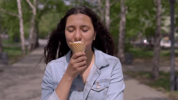 Beautiful Young Girl Eating Ice Cream on a Hot Summer Day