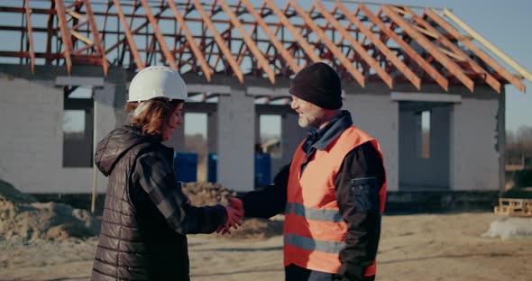 Engineer and Worker Shake Hand on Construction Site