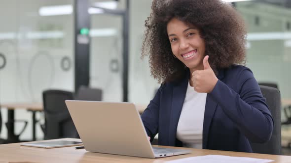 Appreciative Young African Businesswoman with Laptop Doing Thumbs Up